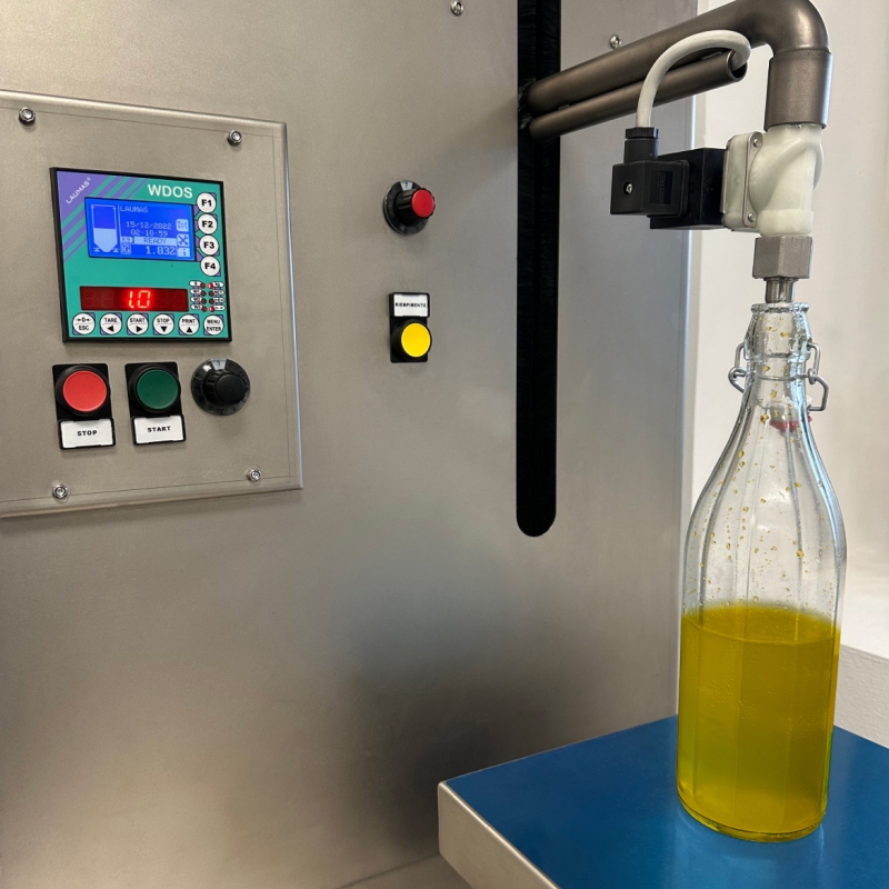 Aplicación del indicador de peso WDOS con programa automático de dosificación en carga en una máquina de llenado semiautomática de aceite.
