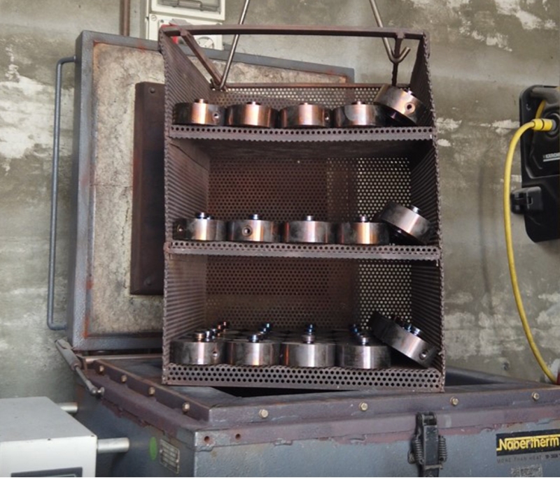 Load cells arranged in batches in an industrial furnace, where they will undergo aging heat treatment.